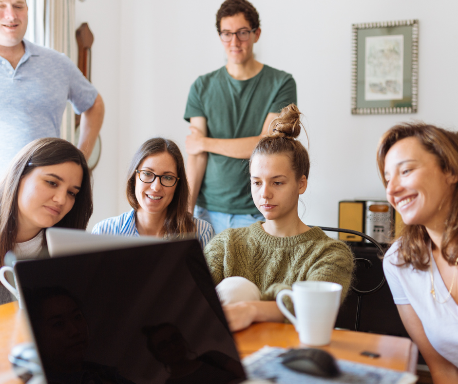 Team gathered on a video call around a laptop